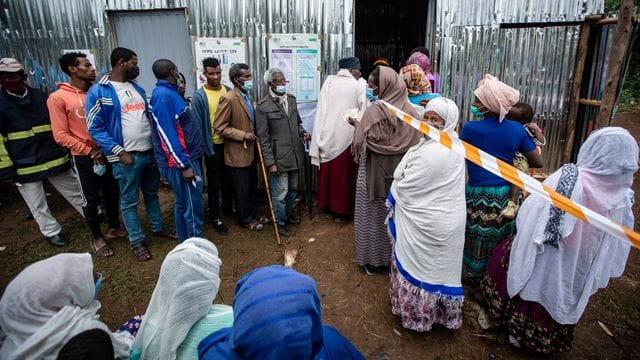 Menschen stehen vor einem Wahllokal in Addis Abeba Schlange.