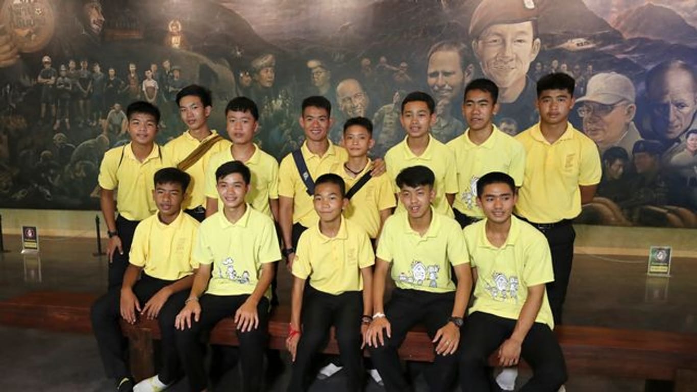 Die 12 Jungs der Fußballmannschaft der "Wildschweine" aus Mae Sai und ihr ehemalige Fußballtrainer Ekkapol Chanthawong (4.