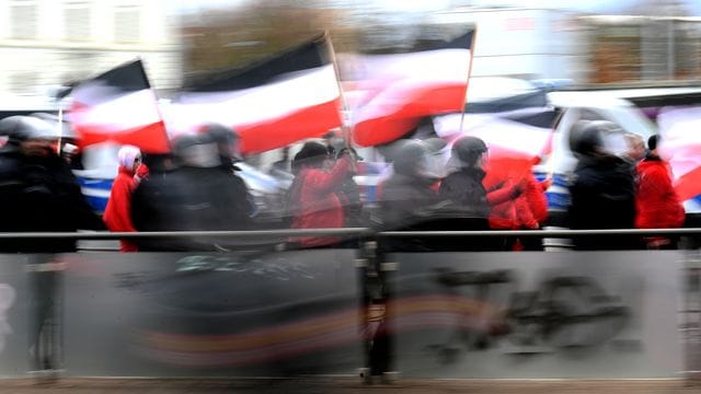 Teilnehmer einer Neonazi-Demonstration werden von der Polizei begleitet.