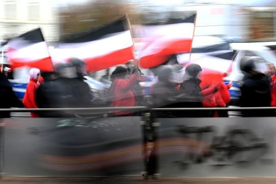 Teilnehmer einer Neonazi-Demonstration werden von der Polizei begleitet.