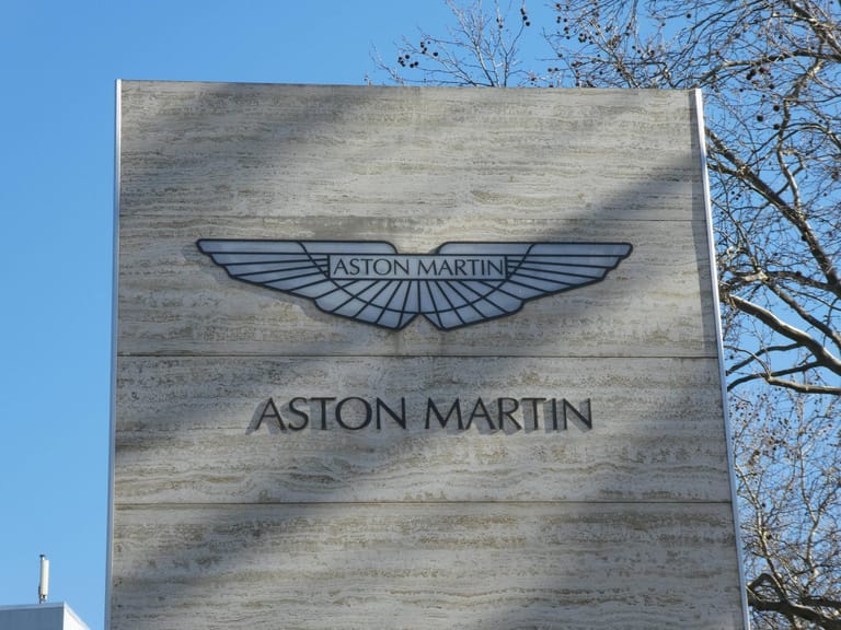 Aston Martin: Der britische Hersteller wurde 1913 von Lionel Martin und Robert Bamford gegründet. Martin findet sich im Namen wieder – und das Aston Clinton Hill Climb Autorennen, welches Lionel Martin 1914 im neusten Modell der Tüftler gewann.