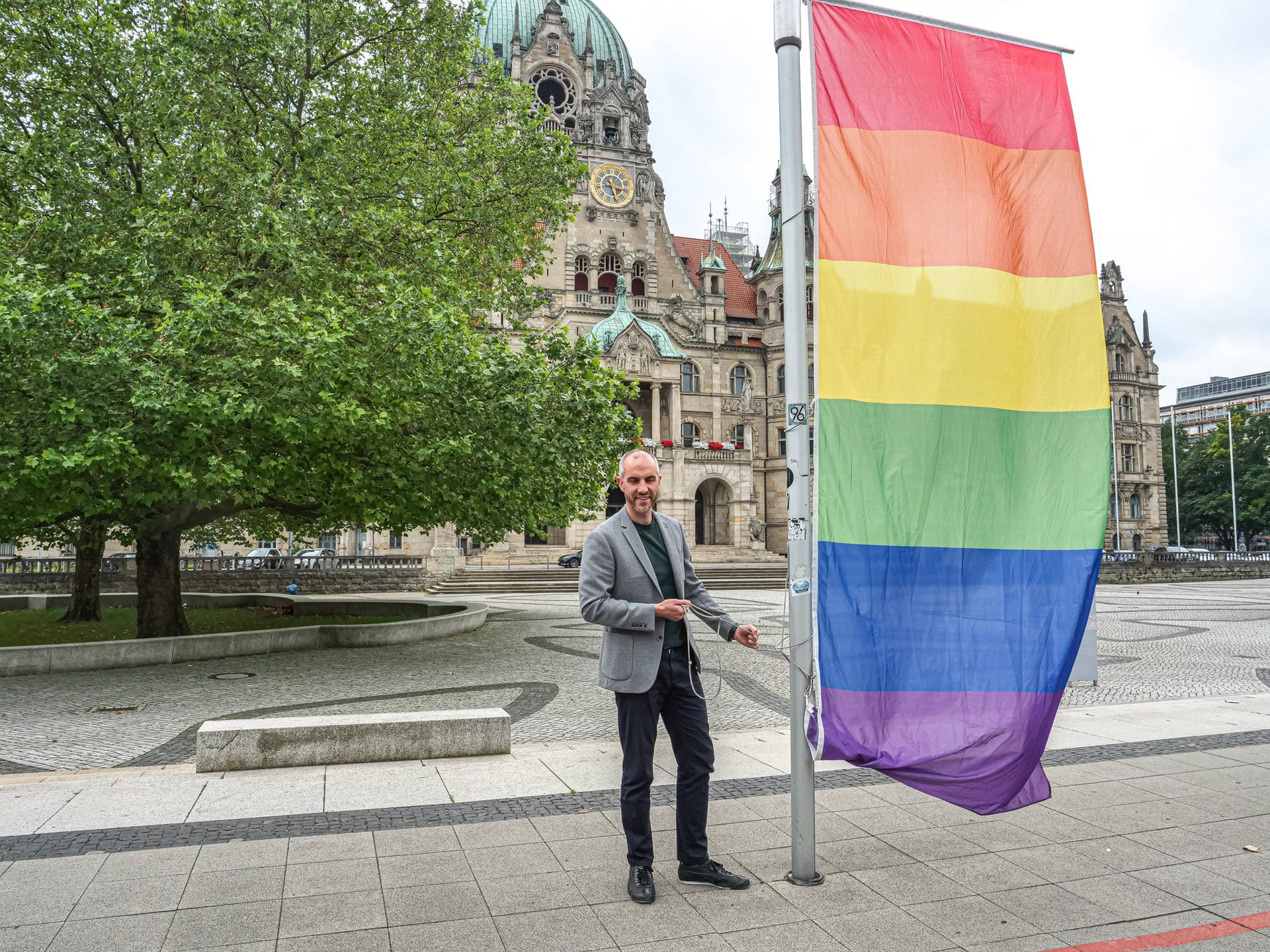 Hannover ist bunt: Oberbürgermeister Belit Onay hisst selber die letzte der acht Regenbogenfahnen vor dem Neuen Rathaus.