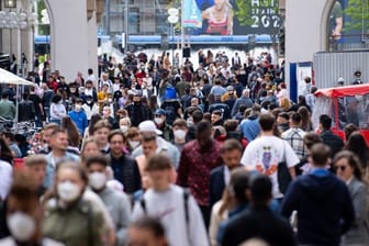 Zahlreiche Menschen spazieren durch die Fußgängerzone in der Innenstadt.