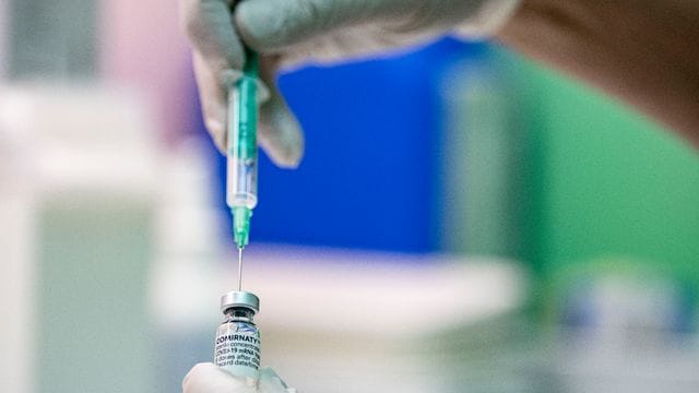 Ein Arzt zieht den Corona-Impfstoff Comirnaty von Biontech/Pfizer in eine Spritze. Ein Arzt zieht den Corona-Impfstoff Comirnaty von Biontech/Pfizer in eine Spritze.