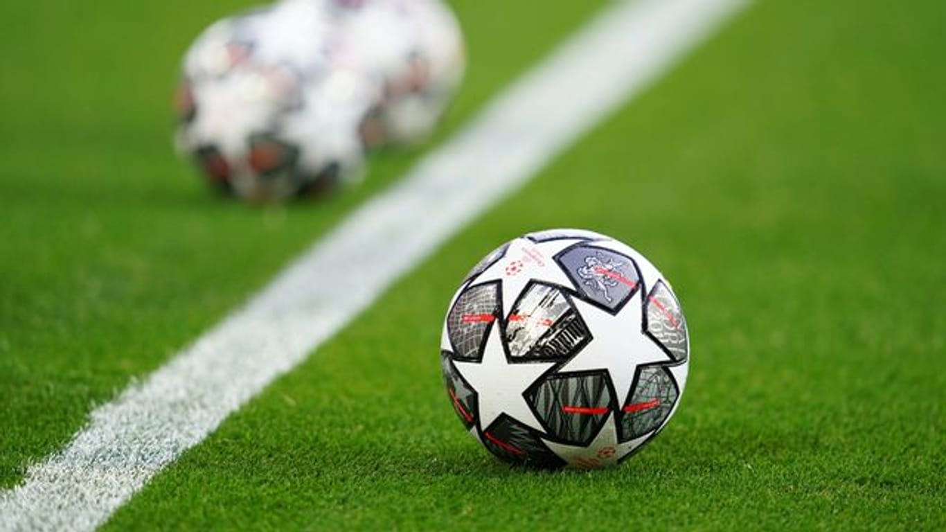 Champions-League-Spielbälle liegen vor einer Partie auf dem Rasen.