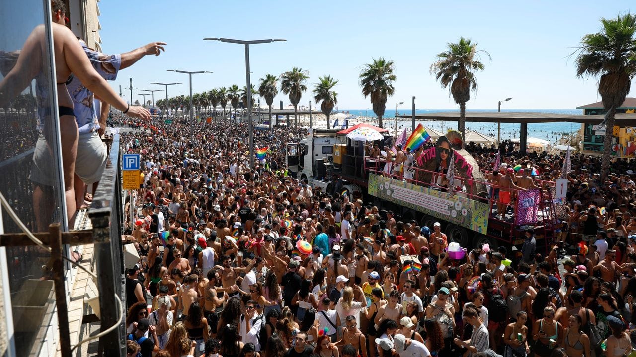 Teilnehmende halten Fahnen, Fächer und Schirme in Regenbogenfarben bei der jährlichen Pride Parade. Teilnehmende halten Fahnen, Fächer und Schirme in Regenbogenfarben bei der jährlichen Pride Parade.