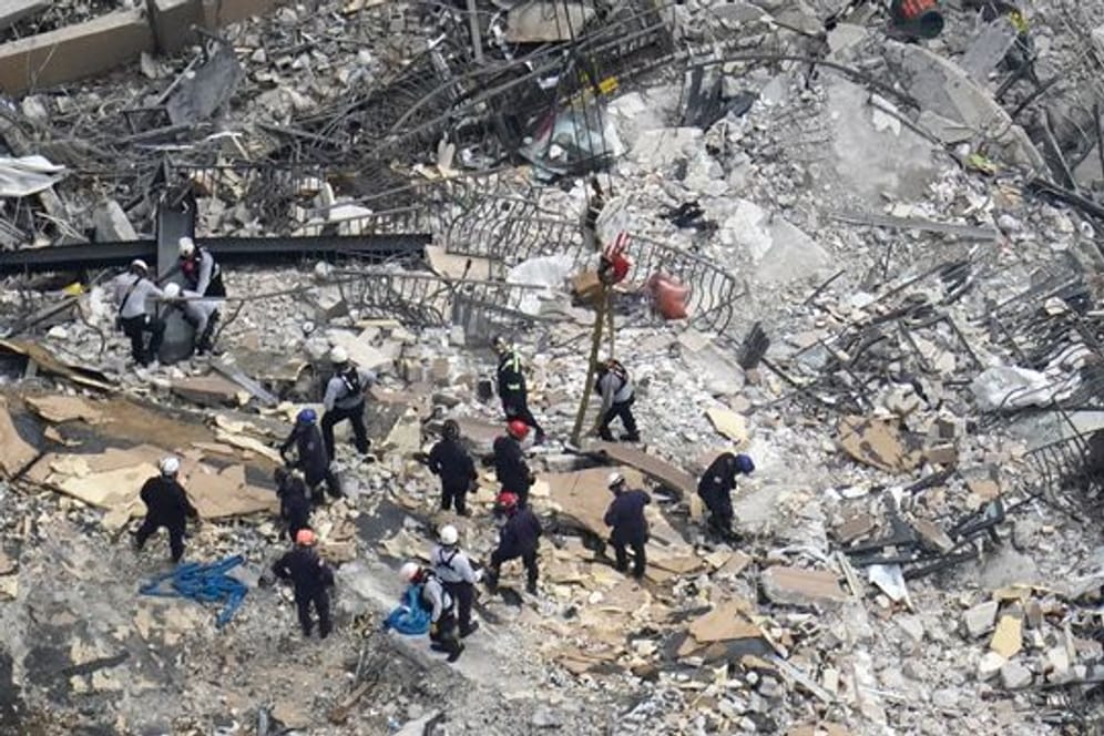 Such- und Rettungskräfte suchen nach Überlebenden in den Trümmern im dem teilweise eingestürzten zwölfstöckigen Gebäude.