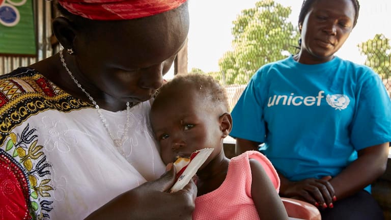 UNICEF-Helferin Jesca hat Aduts Mutter die Vorteile der Erdnusspaste erklärt. Nun isst Adut die erste Portion.