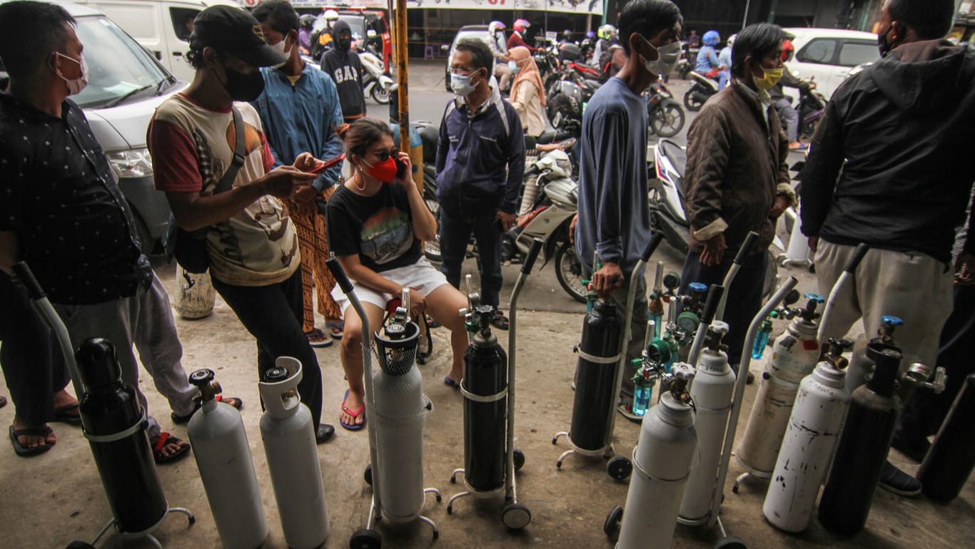 Indonesien: Menschen stehen in einer Schlange, um ihre Sauerstofftanks aufzufüllen.