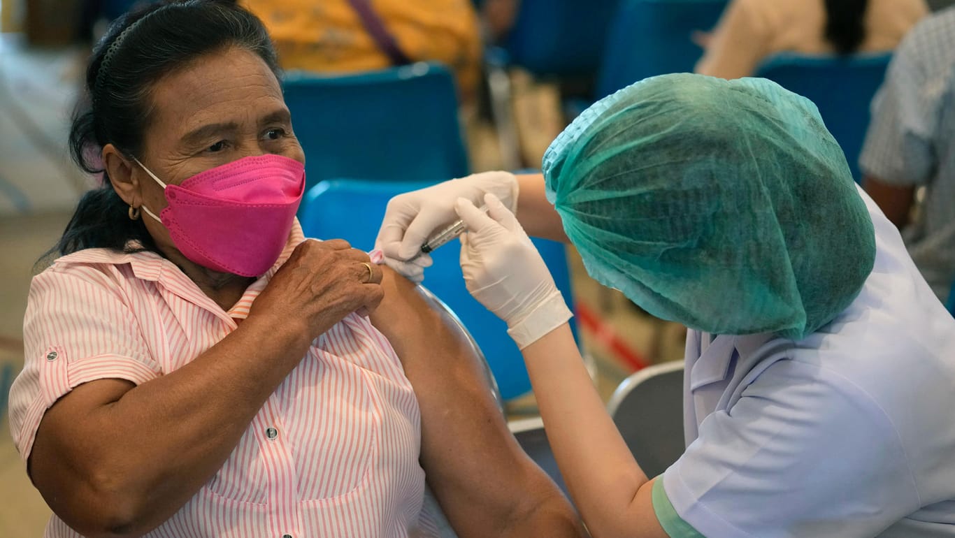 Bangkok: Eine Mitarbeiterin des Gesundheitswesens verabreicht einer Frau eine Dosis des Corona-Impfstoffs Sinopharm.