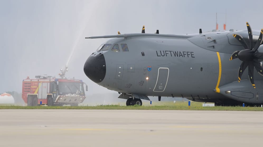 Der Airbus A400M der Luftwaffe wird auf dem Rollfeld mit eine Wasserfontäne der Feuerwehr begrüßt.