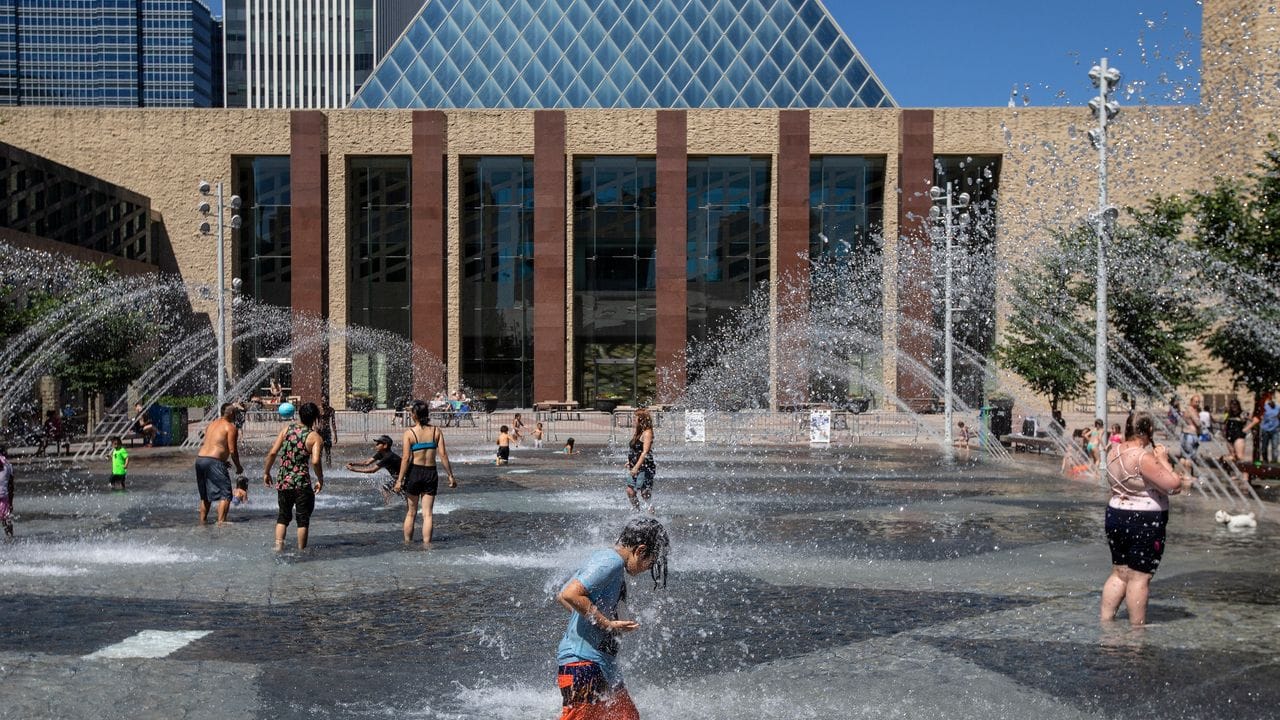 Menschen kühlen sich in einem Wasserbecken des Rathauses in Edmonton ab.