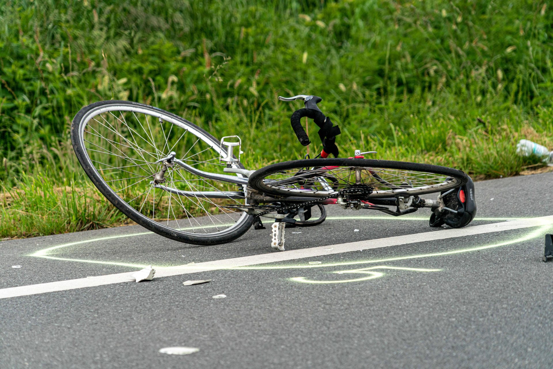 Ein Fahrrad liegt nach einem Unfall auf der Straße (Symbolbild): Die Grenzallee musste über mehrere Stunden gesperrt werden.