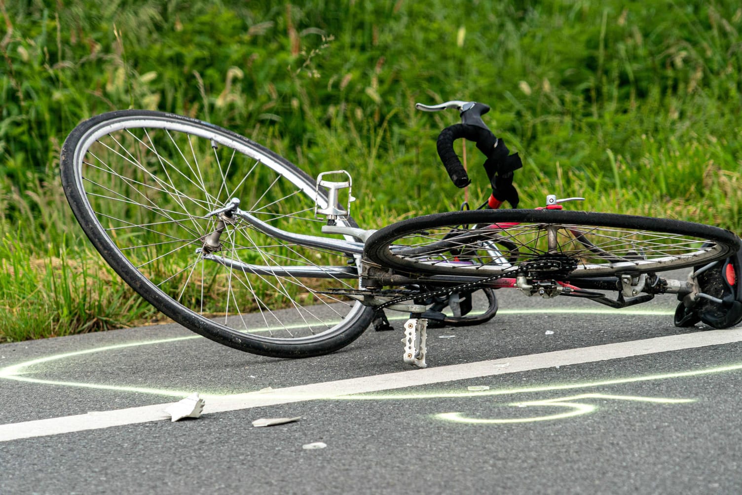 Ein Fahrrad liegt nach einem Unfall auf der Straße (Symbolbild): Die Grenzallee musste über mehrere Stunden gesperrt werden.