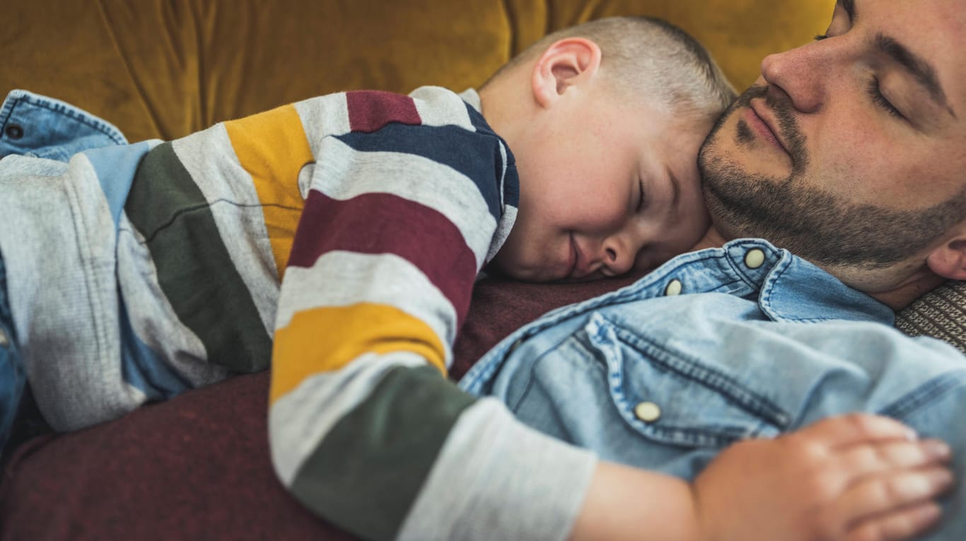 Vater tröstet seinen Sohn: Das Kind sollte man in den Arm nehmen, anstatt es ruckartig zu wecken.