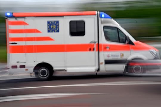 Ein Krankenwagen fährt mit Blaulicht auf einer Straße