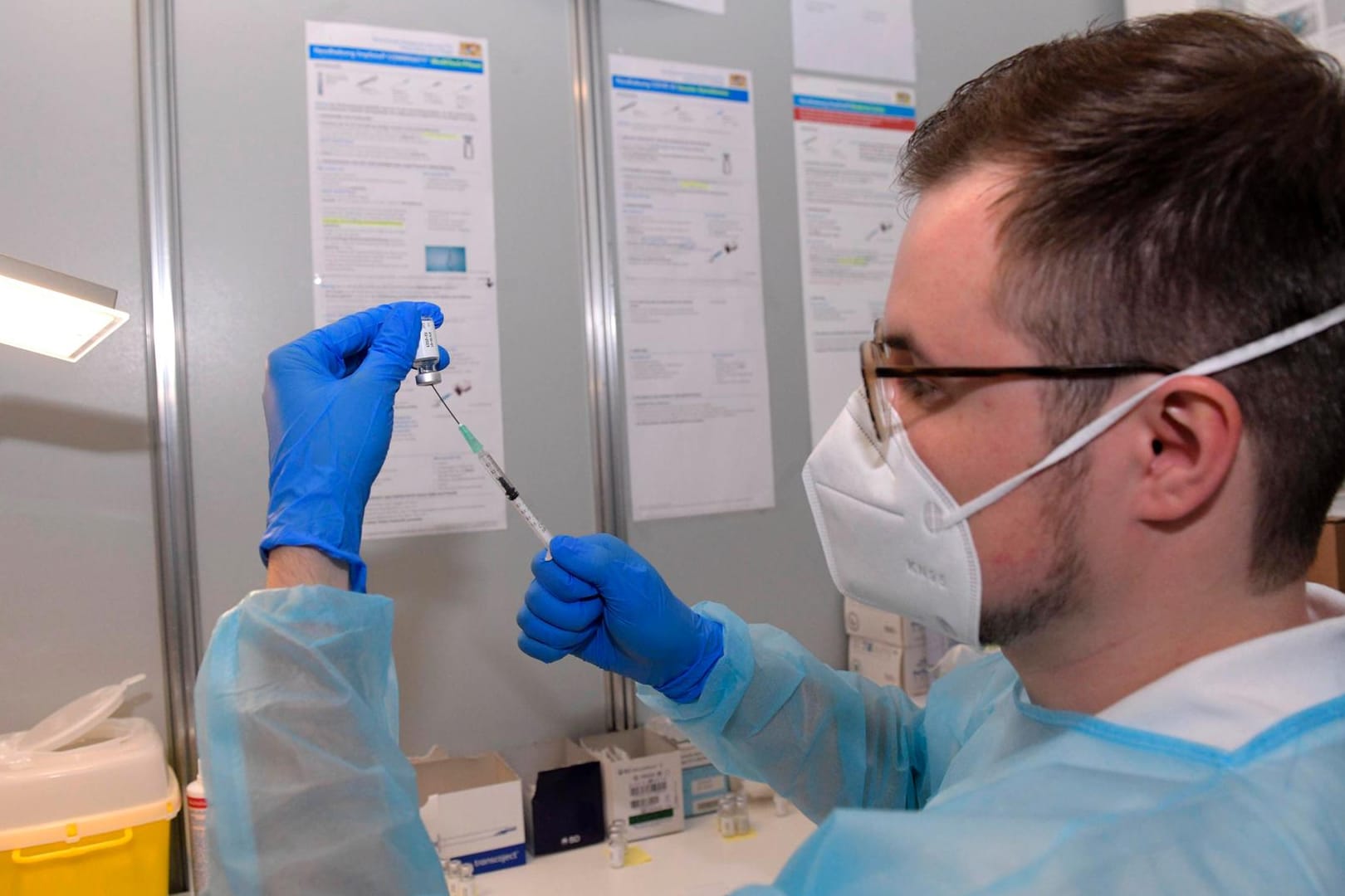 Ein Mitarbeiter in einem Impfzentrum zieht eine Impfspritze auf: Die Impfkomission ändert ihre Empfehlung bezüglich der Astrazeneca-Impfung.