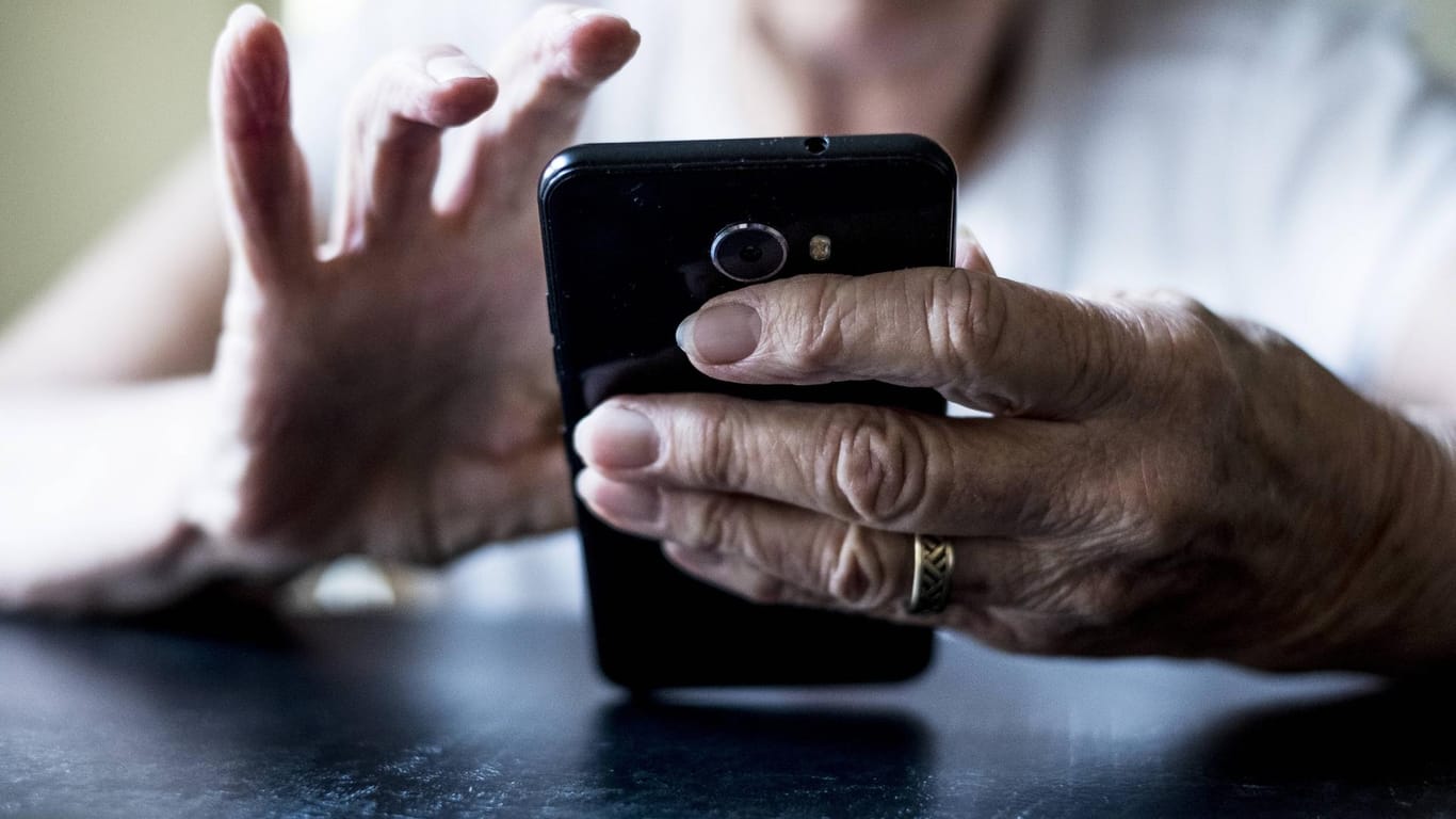 Eine Seniorin hält ein Smartphone in der Hand (Symbolbild): Zwei ältere Menschen sind auf eine Betrugsmasche herein gefallen.