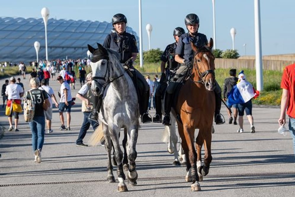 Polizeibeamte der Reiterstaffel patroullieren vor dem EM-Stadion in München.
