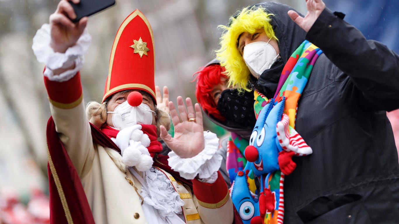 Karnevalisten machen Selfies (Archivbild): In Köln gab es im Jahr 2021 einen außerordentlichen Karneval unter Corona-Restriktionen.