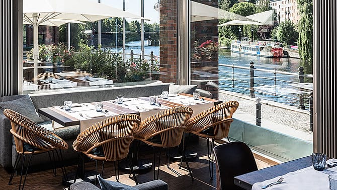 Auf der großzügigen Terrasse mit Blick aufs Wasser können Sie während Ihres Berlin-Aufenthalts köstliche Gerichte probieren.