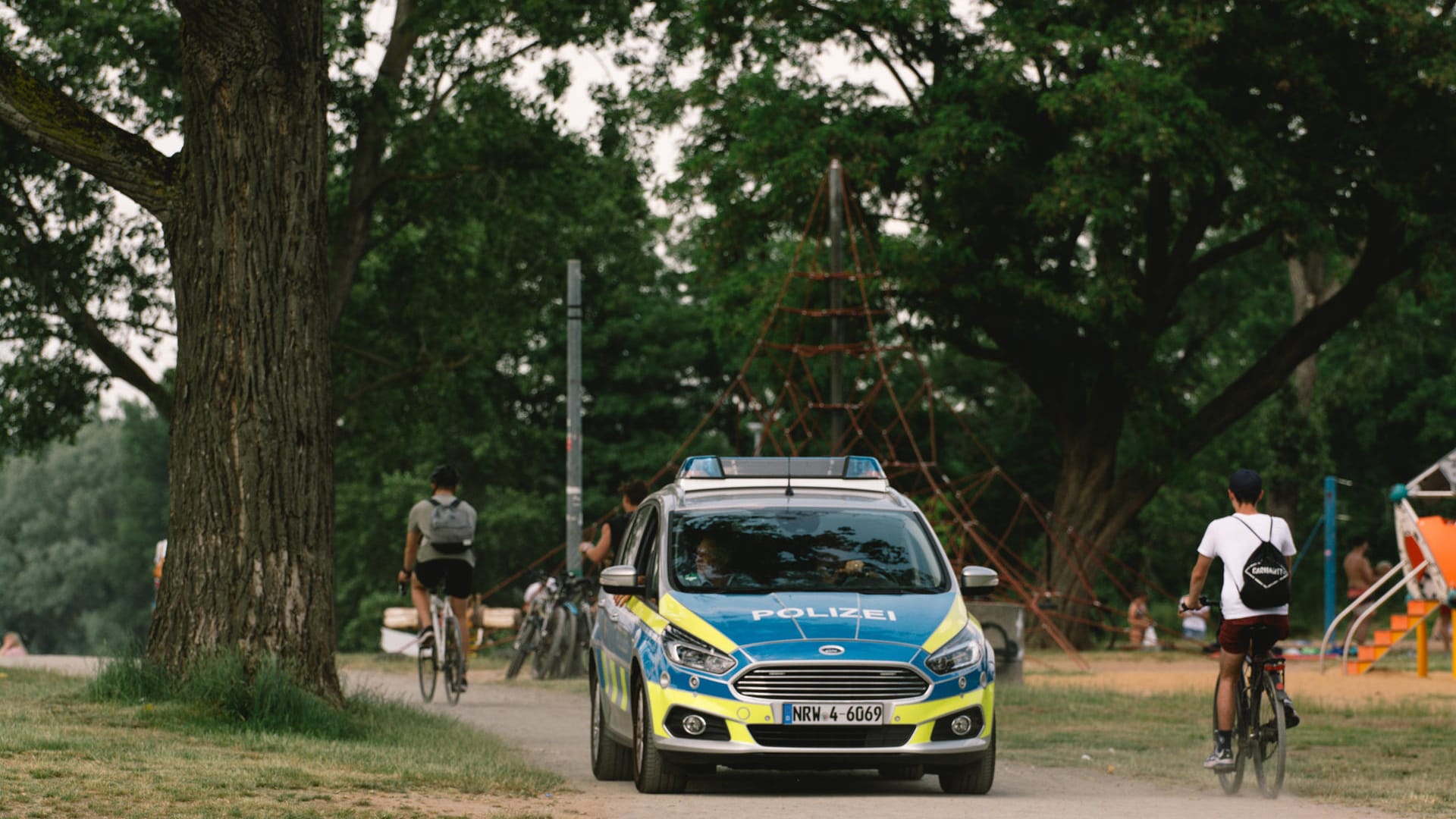 Ein Polizeiwagen fährt durch eine Kölner Grünfläche: Nach mehreren eskalierten Partys hatten Polizei und Ordnungsamt zuletzt durchgegriffen.