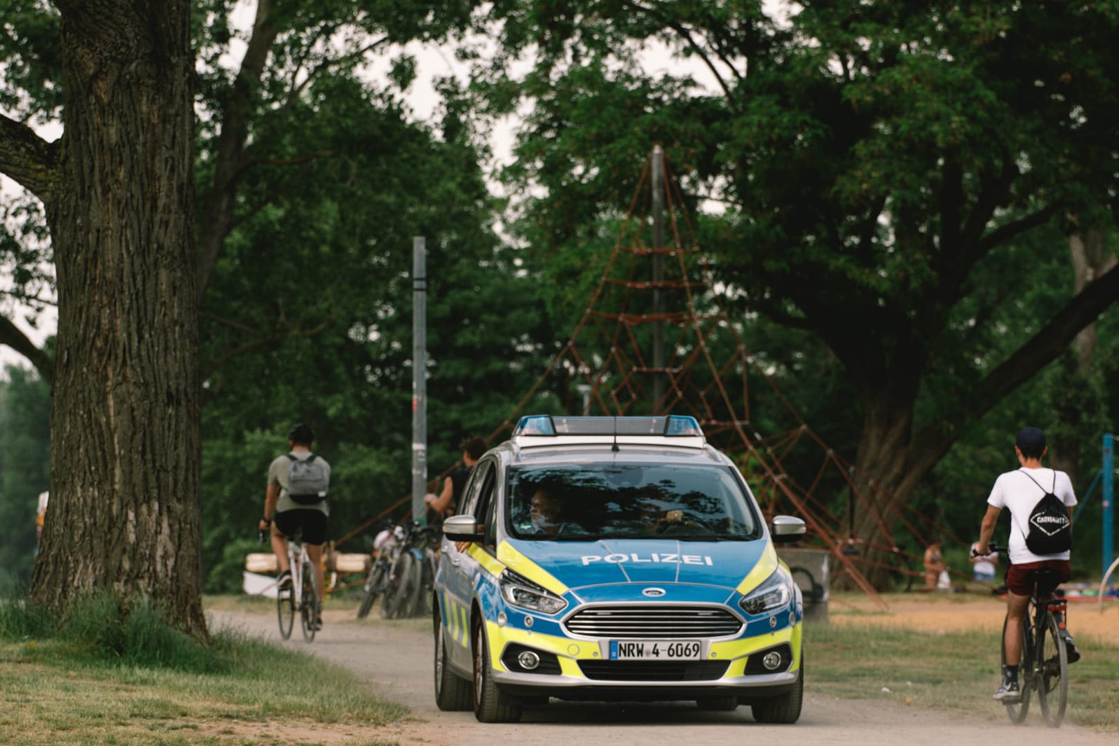 Ein Polizeiwagen fährt durch eine Kölner Grünfläche: Nach mehreren eskalierten Partys hatten Polizei und Ordnungsamt zuletzt durchgegriffen.