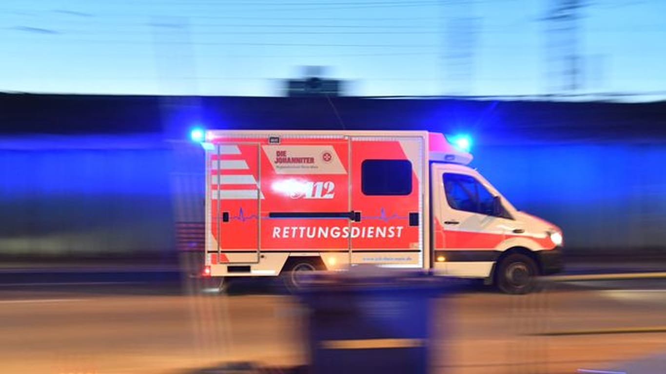 Ein Rettungswagen mit eingeschaltetem Blaulicht fährt auf einer Straße (Symbolbild): In Düsseldorf ist ein Rollstuhlfahrer bei einem Unfall schwer verletzt worden.