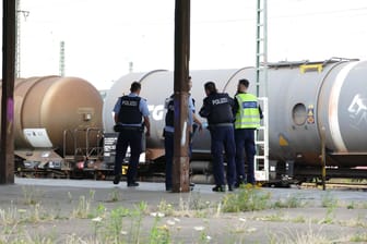 Polizisten stehen an Gleisen in Troisdorf: Ein Kind war auf einen abgestellten Zugwaggon geklettert und hatte einen Stromschlag erlitten.