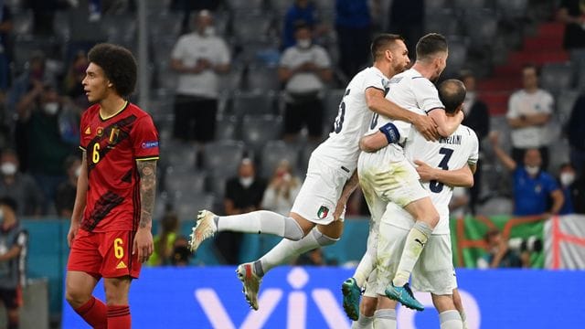 Während Italiens Spieler in München den Halbfinal-Einzug feiern, schaut Belgiens Axel Witsel (l) enttäuscht drein.