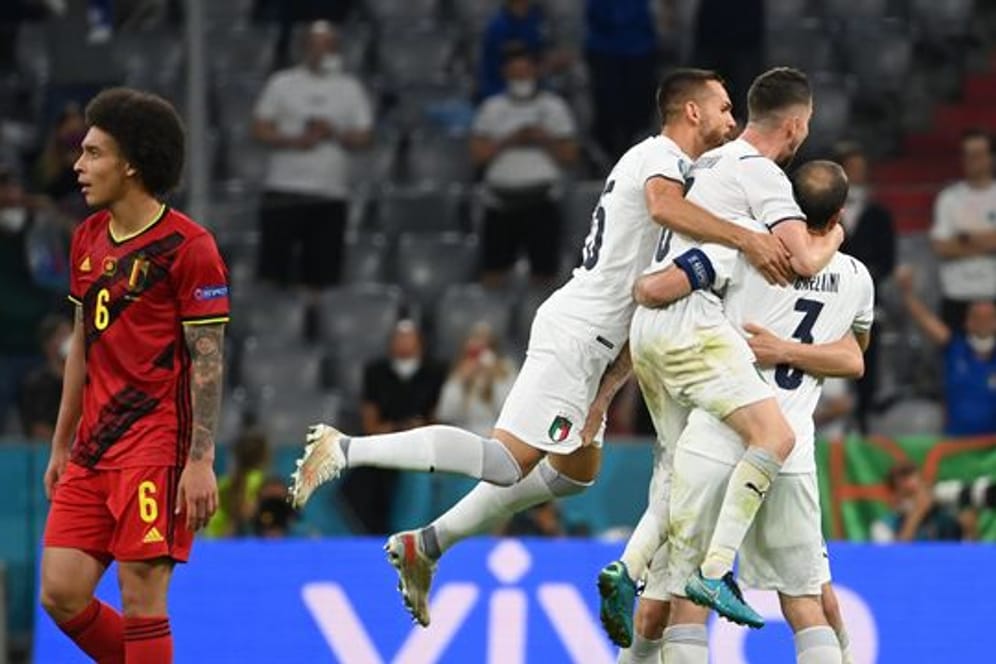 Während Italiens Spieler in München den Halbfinal-Einzug feiern, schaut Belgiens Axel Witsel (l) enttäuscht drein.