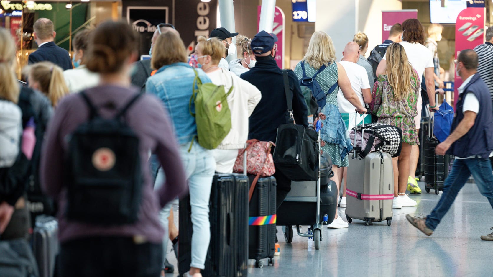 Reisende stehen im Flughafen Düsseldorf vor einem Schalter in einer Schlange: An dem Airport kam es wegen Stornierungen von Flügen in die Türkei zu Problemen.