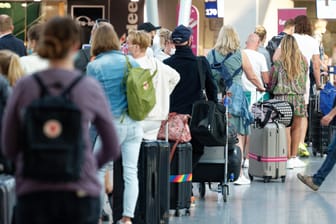 Reisende stehen im Flughafen Düsseldorf vor einem Schalter in einer Schlange: An dem Airport kam es wegen Stornierungen von Flügen in die Türkei zu Problemen.