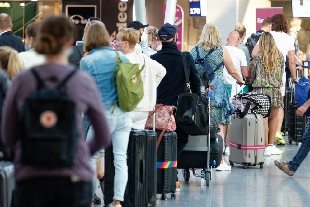 Reisende stehen im Flughafen Düsseldorf vor einem Schalter in einer Schlange: An dem Airport kam es wegen Stornierungen von Flügen in die Türkei zu Problemen.