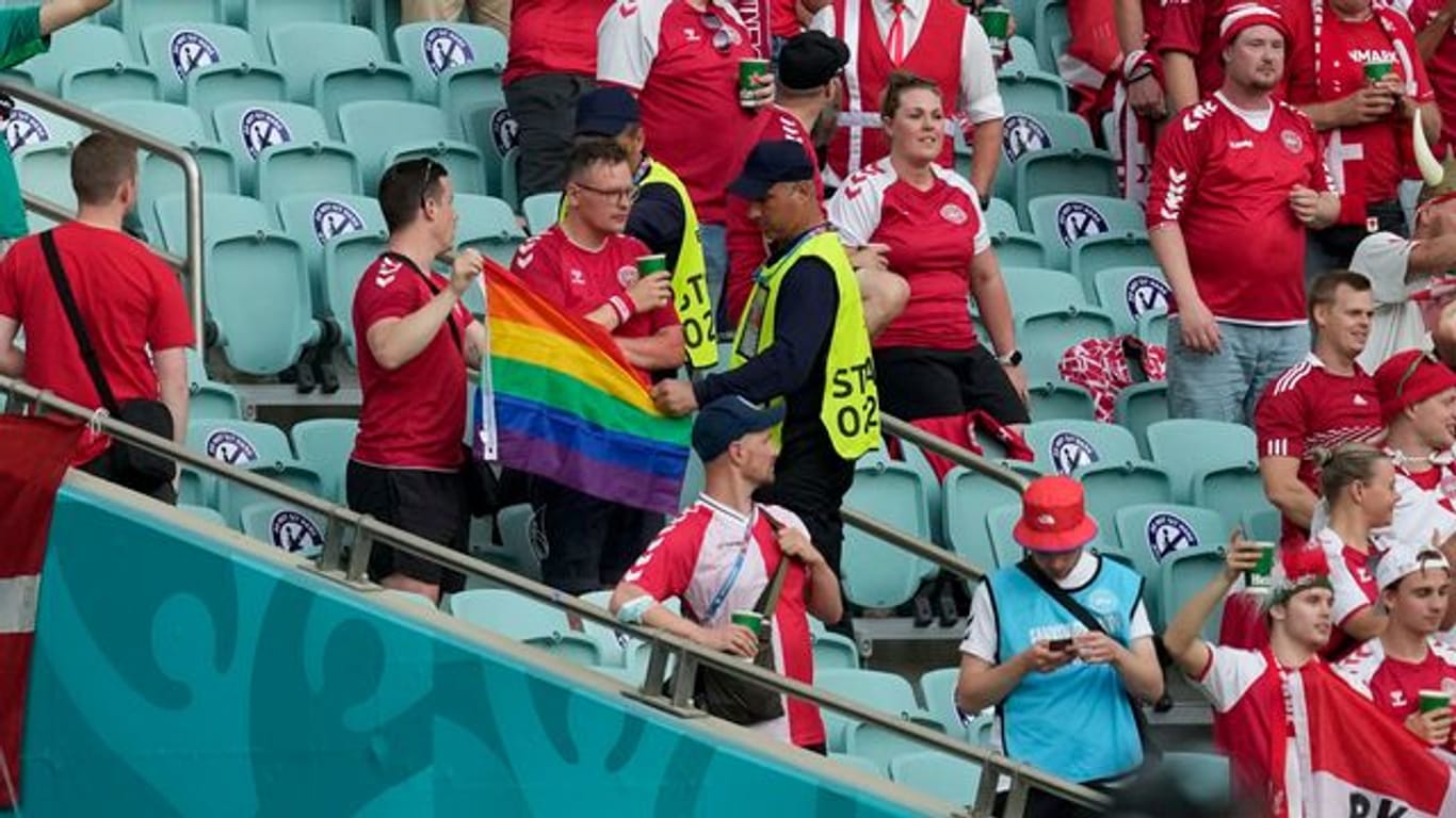 Ordner nehmen zwei Dänemark Fans eine Regenbogen-Fahne ab.