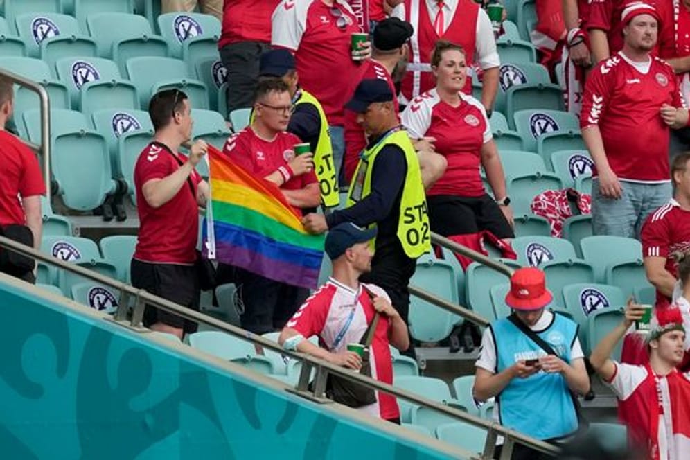 Ordner nehmen zwei Dänemark Fans eine Regenbogen-Fahne ab.