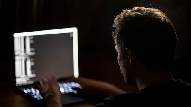Ein Mann schreibt auf der Tastatur eines Laptops (Symbolbild). Ein Mann schreibt auf der Tastatur eines Laptops (Symbolbild).