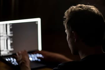 Ein Mann schreibt auf der Tastatur eines Laptops (Symbolbild).
