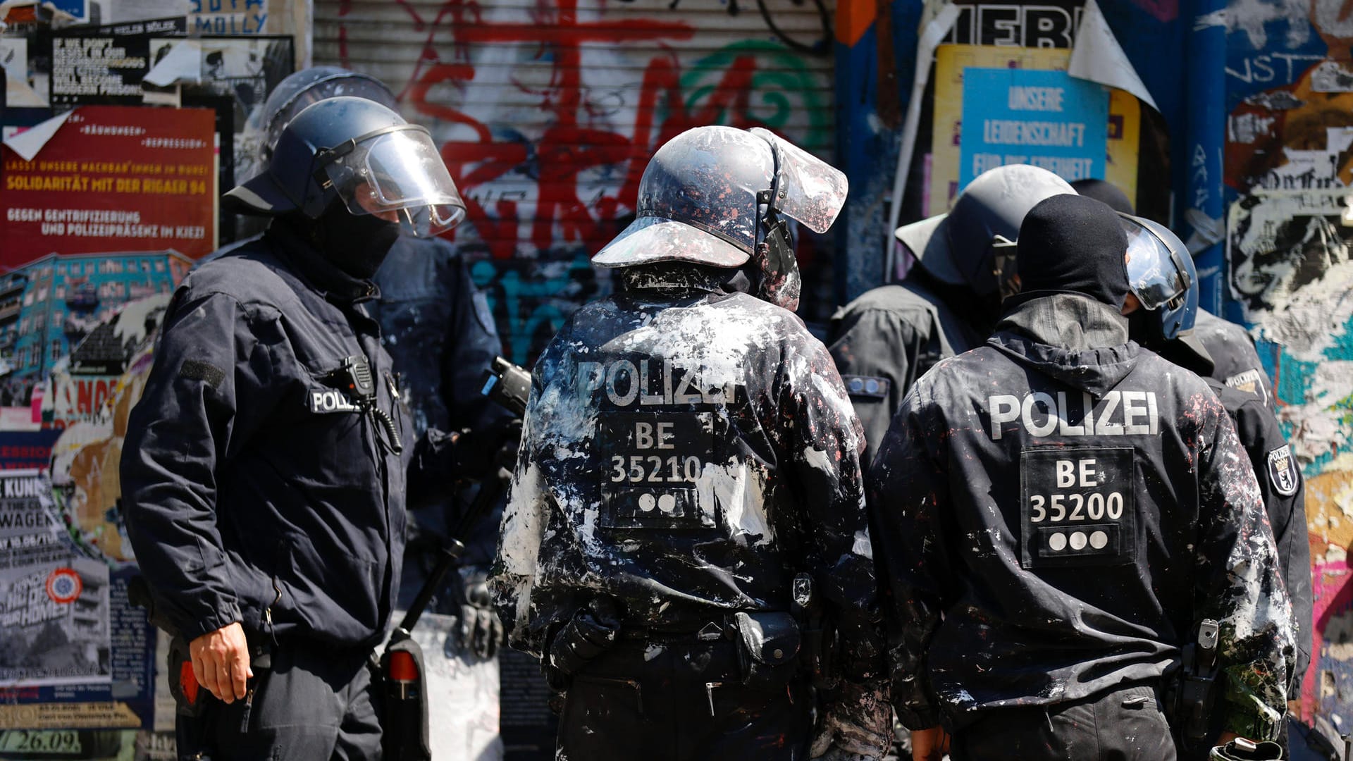 Mit Farbe beschmierte Polizisten stehen vor dem teilbesetzten Haus Rigaer 94 Berlin-Friedrichshain (Archivbild): Sie waren von Anwohnern mit Farbbeuteln beworfen worden.