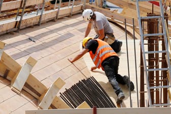 Zwei Arbeiter auf einer Baustelle (Symbolbild): Die Preise für Baumaterial wie Holz und Stahl sind im Mai stark angestiegen