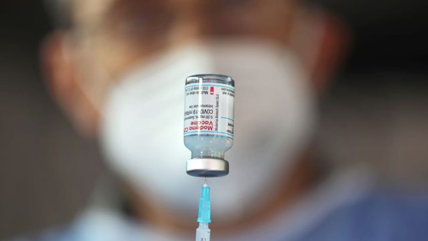 Ein Arzt zieht eine Spritze mit dem Impfstoff von Moderna auf: In Berlin soll jetzt verstärkt auf Kreuzimpfungen gesetzt werden.