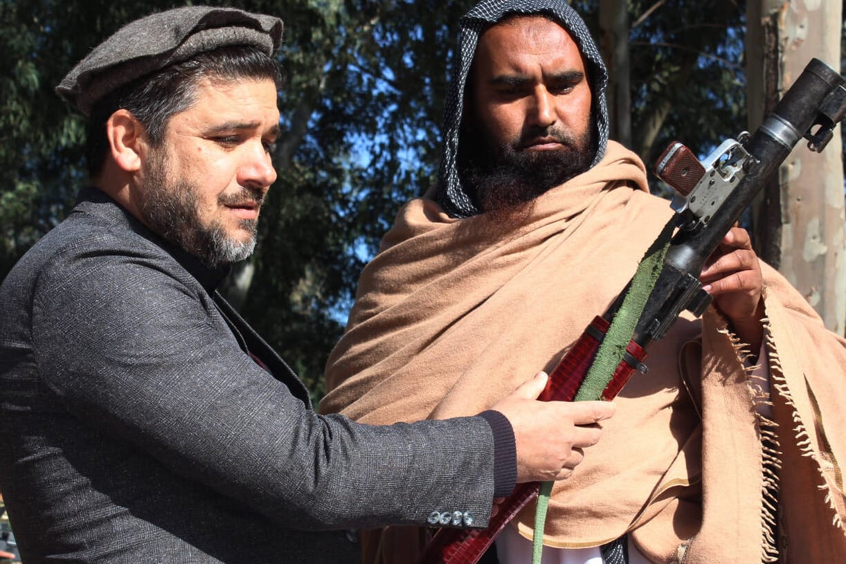 Ein Taliban-Kämpfer (rechts) übergibt ein Gewehr an Regierungsvertreter (Archivbild). Die Rebellen wollen angeblich Friedensgespräche beschleunigen.