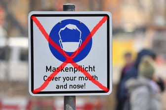 Durchgestrichenes Schild mit der Aufschrift "Maskenpflicht" in einer Fußgängerzone: Bundesaußenminister Heiko Maas hatte sich für eine Aufhebung aller Maßnahmen ausgesprochen, sobald alle Bürger ein Impfangebot erhalten haben (Symbolbild).