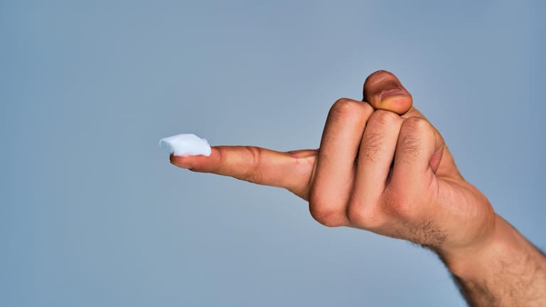 Männliche Hand mit Salbe auf dem Finger: Hämorrhoidensalben und -cremes sollen gegen lästige Symptome Abhilfe schaffen.
