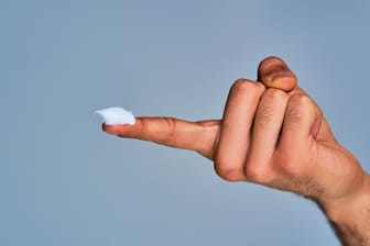 Männliche Hand mit Salbe auf dem Finger: Hämorrhoidensalben und -cremes sollen gegen lästige Symptome Abhilfe schaffen.
