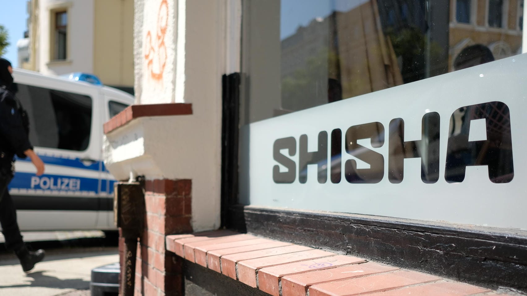 Ein Polizist geht vor einer Shishabar entlang: In der Stadt wurden mehrere Shishabars und Dönerimbisse durchsucht. Ein Polizist geht vor einer Shishabar entlang: In der Stadt wurden mehrere Shishabars und Dönerimbisse durchsucht.