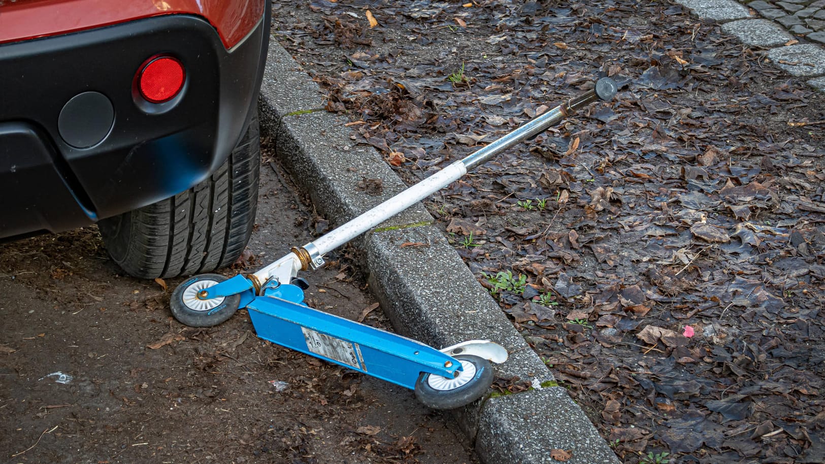 Ein Tretroller liegt nahe eines Autos (Symbolbild): In Wuppertal ist es zu einem Unfall mit einem jungen Rollerfahrer und einem Auto gekommen. Ein Tretroller liegt nahe eines Autos (Symbolbild): In Wuppertal ist es zu einem Unfall mit einem jungen Rollerfahrer und einem Auto gekommen.