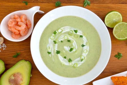 Zur pürierten Avocado-Kaltschale mit Eiswürfeln passen gekochte Garnelen oder Nachos.