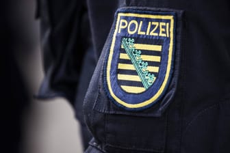 Das Wappen der sächsischen Polizei auf einer Uniform (Symbolbild): Spezialisten des Terrorismus- und Extremismus-Abwehrzentrums des Landeskriminalamtes Sachsen ermitteln zu dem Fall.