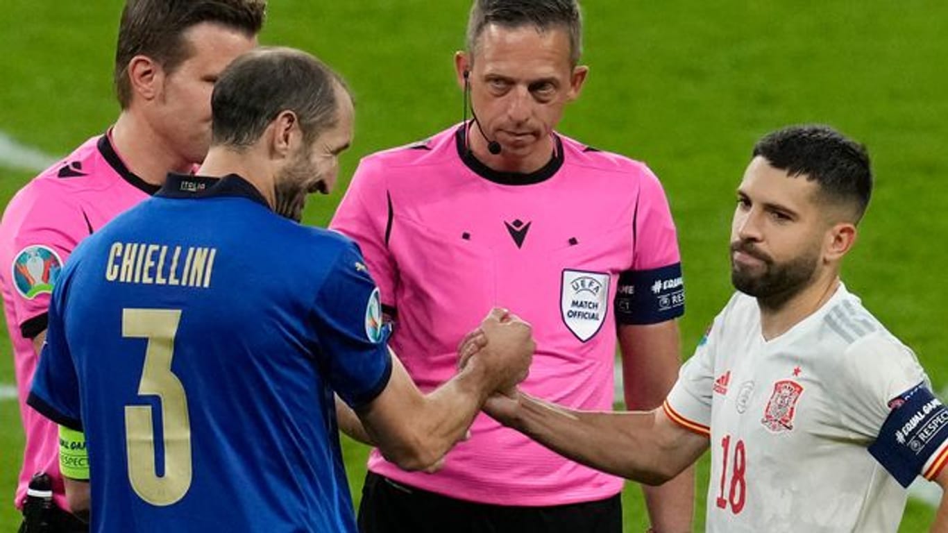 Im Gegensatz zum gut gelaunten italienischen Kapitän Giorgio Chiellini scheint Spaniens Jordi Alba nach dem Münzwurf unzufrieden zu sein.